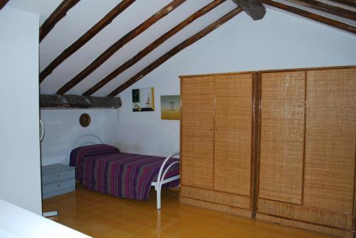 a bedroom with a bed and a wooden closet at Appartamento Paradise in Fondachello
