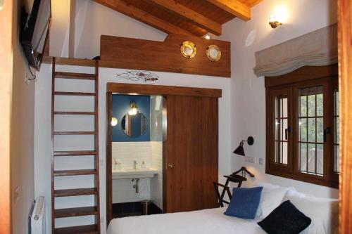 ein Schlafzimmer mit einem Etagenbett und einer Leiter zu einem Badezimmer in der Unterkunft Molino de La Médica Casa Rural de Lujo en Gredos in Candeleda