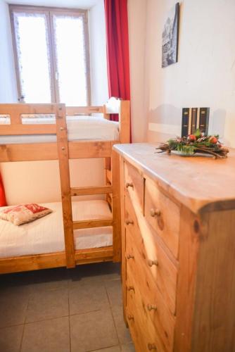 Cette chambre comprend 2 lits superposés et une armoire en bois. dans l'établissement Studio cosy à Valloire, 25 m² avec jardin privé, à Valloire