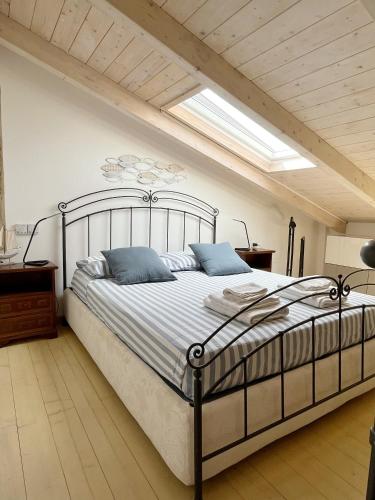 a bedroom with a large bed with blue pillows at Domo del Convento in Alghero