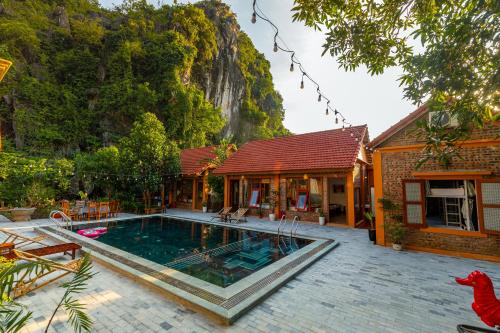 uma casa com piscina em frente a uma montanha em Tam Coc mountain bungalow em Ninh Binh