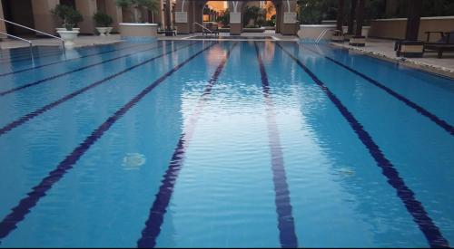 a large swimming pool with blue water at The Key - Luxury Apartment in Doha