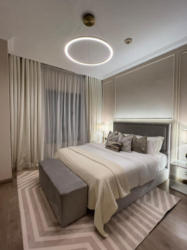 a bedroom with a large bed and a light fixture at The Key - Luxury Apartment in Doha