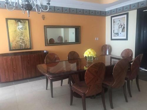 Room in House - Casa De Playa Alegria, Flamingo, في بلايا فلامنغو: غرفة طعام مع طاولة وكراسي خشبية