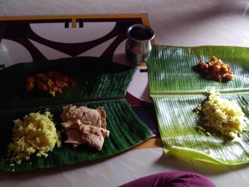 two green plates with different types of food on them at NeemTree Homestay NewHampi in New Hampi