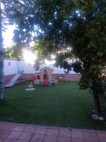 un patio trasero con un parque infantil con un tobogán en Berna en Jerez de la Frontera