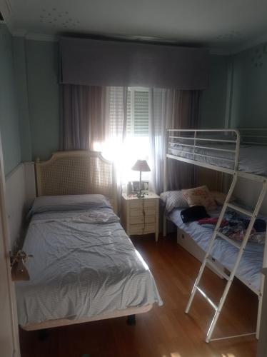1 dormitorio con 2 literas y ventana en Berna, en Jerez de la Frontera
