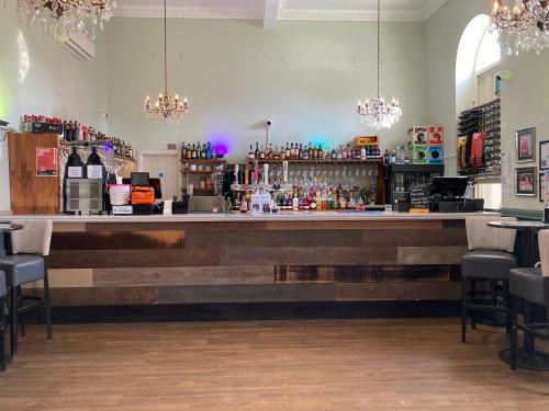 a bar with a long counter and some chairs at Kings Hotel in Newmarket