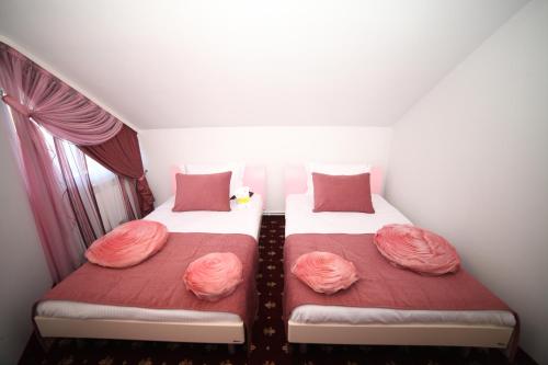 two beds in a small room with red and pink pillows at Multi Rest House in Tsaghkadzor