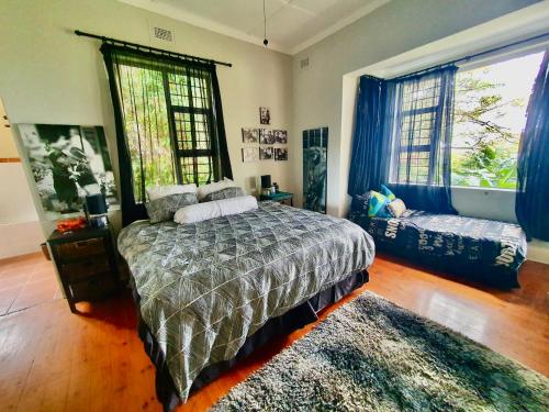 a bedroom with a bed and a large window at 23 Ambleside Holiday Retreat by the sea in Port Shepstone