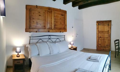 een slaapkamer met een groot wit bed met 2 lampen bij Casa BORRIERO Farmhouse in Sospirolo