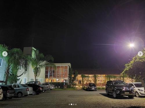 a parking lot with cars parked in front of a building at Flex Hotel in Canoinhas