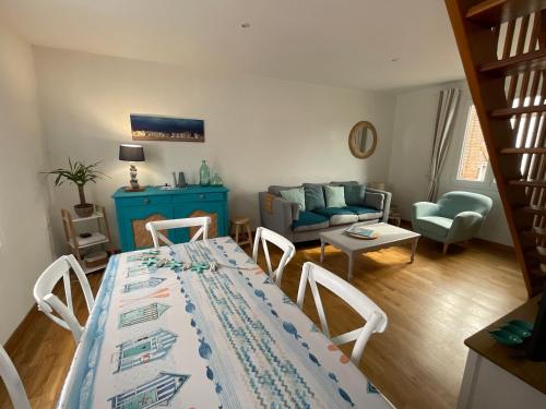 un salon avec une table et un canapé bleu dans l'établissement le Cottage de la Plage - Maison avec garage, à Mers-les-Bains