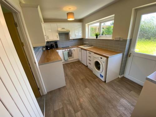 a kitchen with a washer and dryer at Cosy bungalow in countryside village near coast in Pembroke