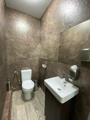 a bathroom with a white toilet and a sink at Hotel Atmosphere in Poltava