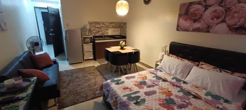 a bedroom with a bed and a kitchen with a refrigerator at Katliza Condotel Kassel Residences in Manila