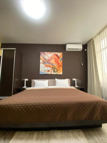 a bedroom with a bed with a painting on the wall at Hotel Atmosphere in Poltava