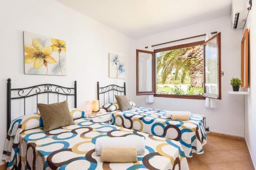 a bedroom with two beds and a window at Villa Amapola by Villa Plus in Santo Tomás