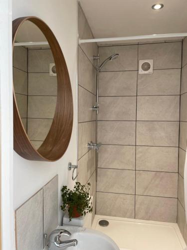 a bathroom with a shower with a sink and a mirror at Rossendale Holiday Cottages in Rossendale