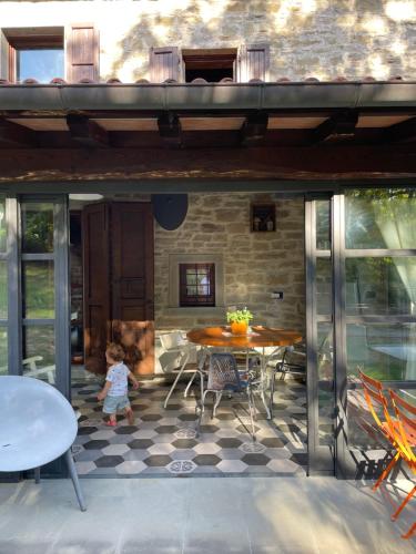 un bambino che cammina su un patio con tavolo e sedie di Ca' Maranghi Holiday House a Palazzuolo sul Senio