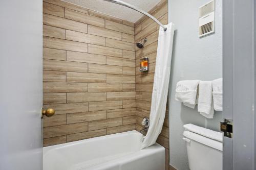 a bathroom with a white tub and a toilet at The Guest Lodge Gainesville in Gainesville