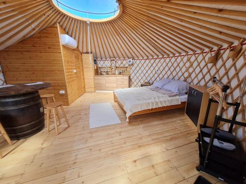 a bedroom in a yurt with a bed and a table at Jurtafarm Ráckeve - a nomád luxus in Ráckeve