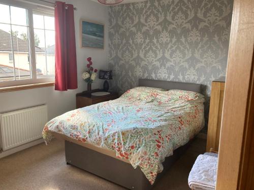 a bedroom with a bed with a floral comforter at Caledonia House in Rosyth