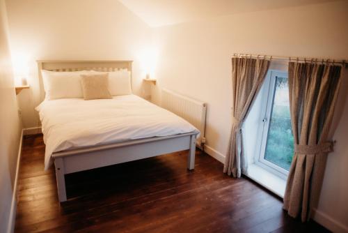 a small bedroom with a bed and a window at Rossendale Holiday Cottages & Spa in Rossendale