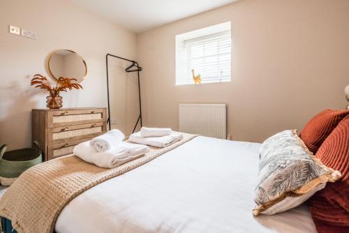 a bedroom with a bed with towels on it at Guildhall Street Apartment in Bury Saint Edmunds