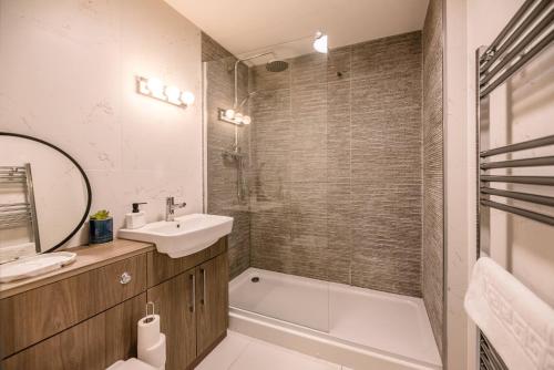 a bathroom with a sink and a bath tub and a mirror at Guildhall Street Apartment in Bury Saint Edmunds