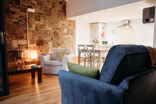 uma sala de estar com um sofá e uma mesa em Rossendale Holiday Cottages em Rossendale