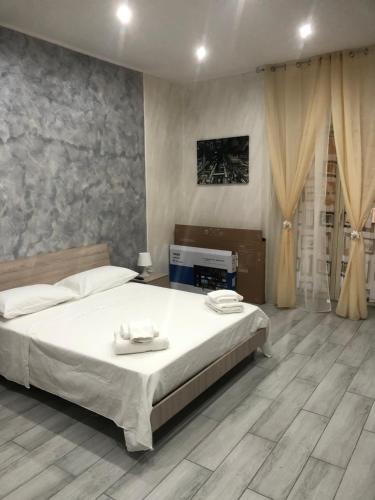 een slaapkamer met een groot wit bed en houten vloeren bij Casa Vacanza Grey in Napels