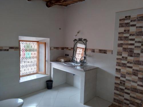a bathroom with a sink and a window at Hotel et Restaurant Riad Amodou in Tinerhir
