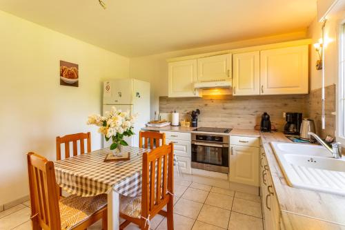 une cuisine avec une table, des chaises et un évier dans l'établissement La Julienne, à Beussent