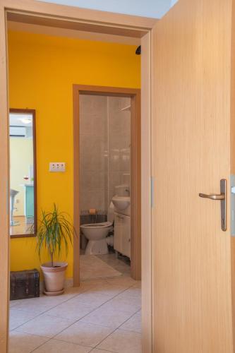 a bathroom with two toilets and a yellow wall at Apartman Silvija in Osijek