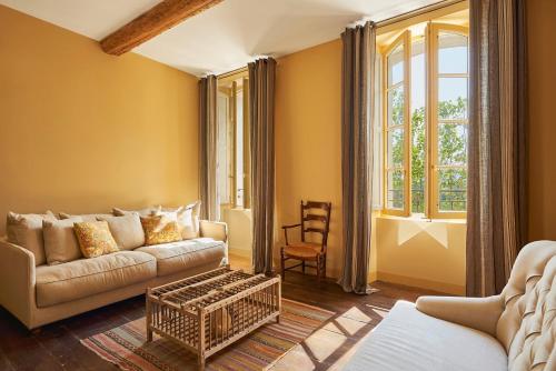 ein Wohnzimmer mit einem Sofa und einem Fenster in der Unterkunft Château Saint Roux Le Luc-Le Cannet des Maures in Le Cannet-des-Maures