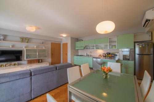 a kitchen and living room with a couch and a table at Apartman Silvija in Osijek