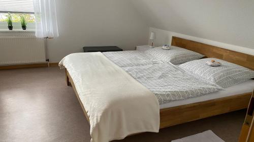 1 dormitorio con 1 cama grande con sábanas blancas en Ferienwohnung Fresch, en Heiligenhafen