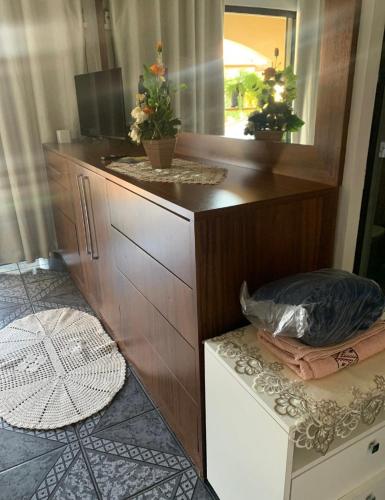 een dressoir met een spiegel in een kamer bij Suíte Aconchego in Blumenau