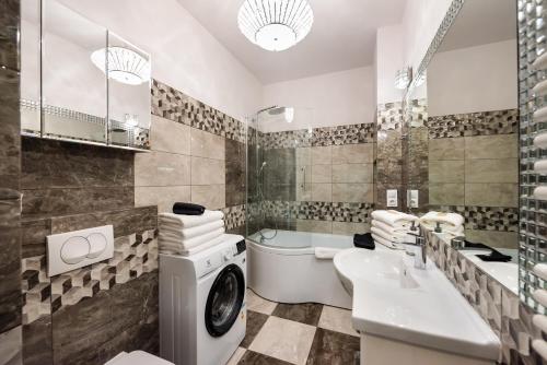 Prestige Verdant Apartment في وارسو: حمام مع غسالة ومغسلة
