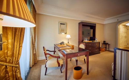 a hotel room with a desk and a television at Falkensteiner Schlosshotel Velden – The Leading Hotels of the World in Velden am Wörthersee