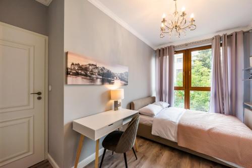 Prestige Verdant Apartment في وارسو: غرفة نوم بسرير ومكتب ونافذة