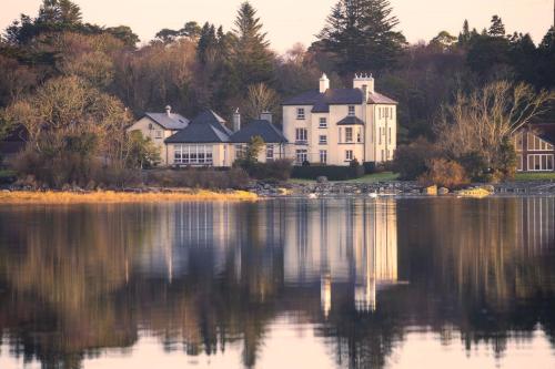 a large house sitting on the shore of a lake at Screebe House in Rosmuck