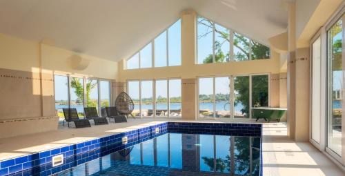 a swimming pool in a house with large windows at Screebe House in Rosmuck