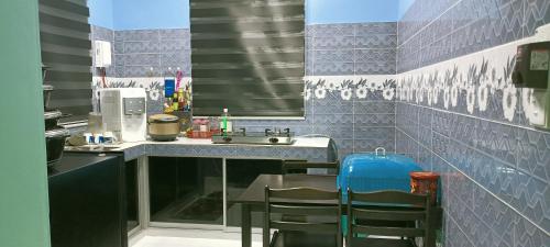 a kitchen with a sink and a table with chairs at HOMESTAY PAK TEH in Kota Bharu