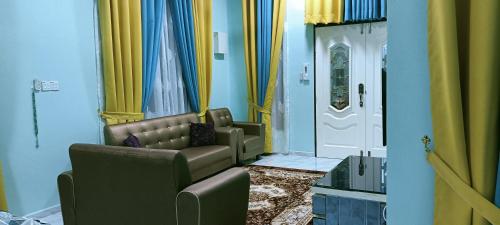 a living room with two chairs and a door at HOMESTAY PAK TEH in Kota Bharu