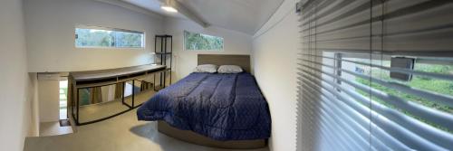um quarto com uma cama no canto de um quarto em Tiny Houses en Asunción. Zona Aeropuerto-Rakiura em Zarate Isla