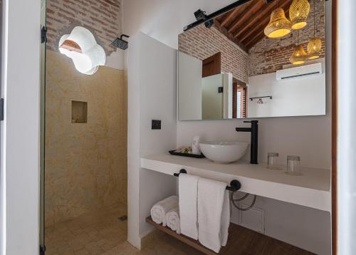 a white bathroom with a sink and a mirror at Voila Getsemani in Cartagena de Indias