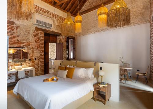 Un dormitorio con una gran cama blanca en una habitación. en Hotel Voilá Getsemaní, en Cartagena de Indias