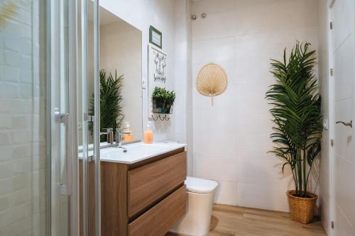 ein Bad mit einem Waschbecken, einem WC und Pflanzen in der Unterkunft Divi Apartments Martínez Montañes in Sevilla